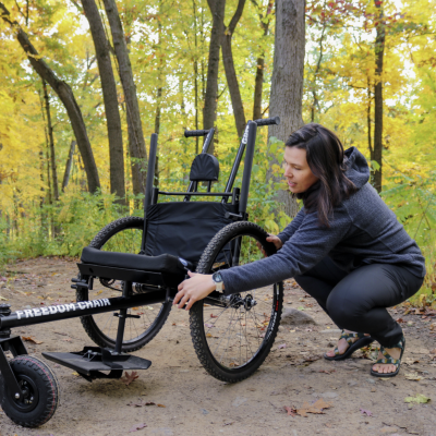 Kiley Adams adjusts the trailchair while on a trail at nichols arboretum