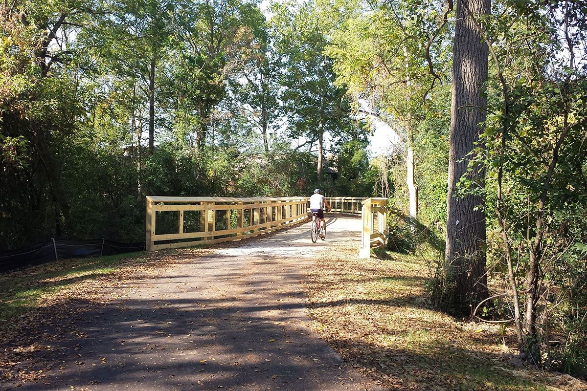 Bicycle rider crossing a bridge on the Matthaei Botanical Gardens Trail