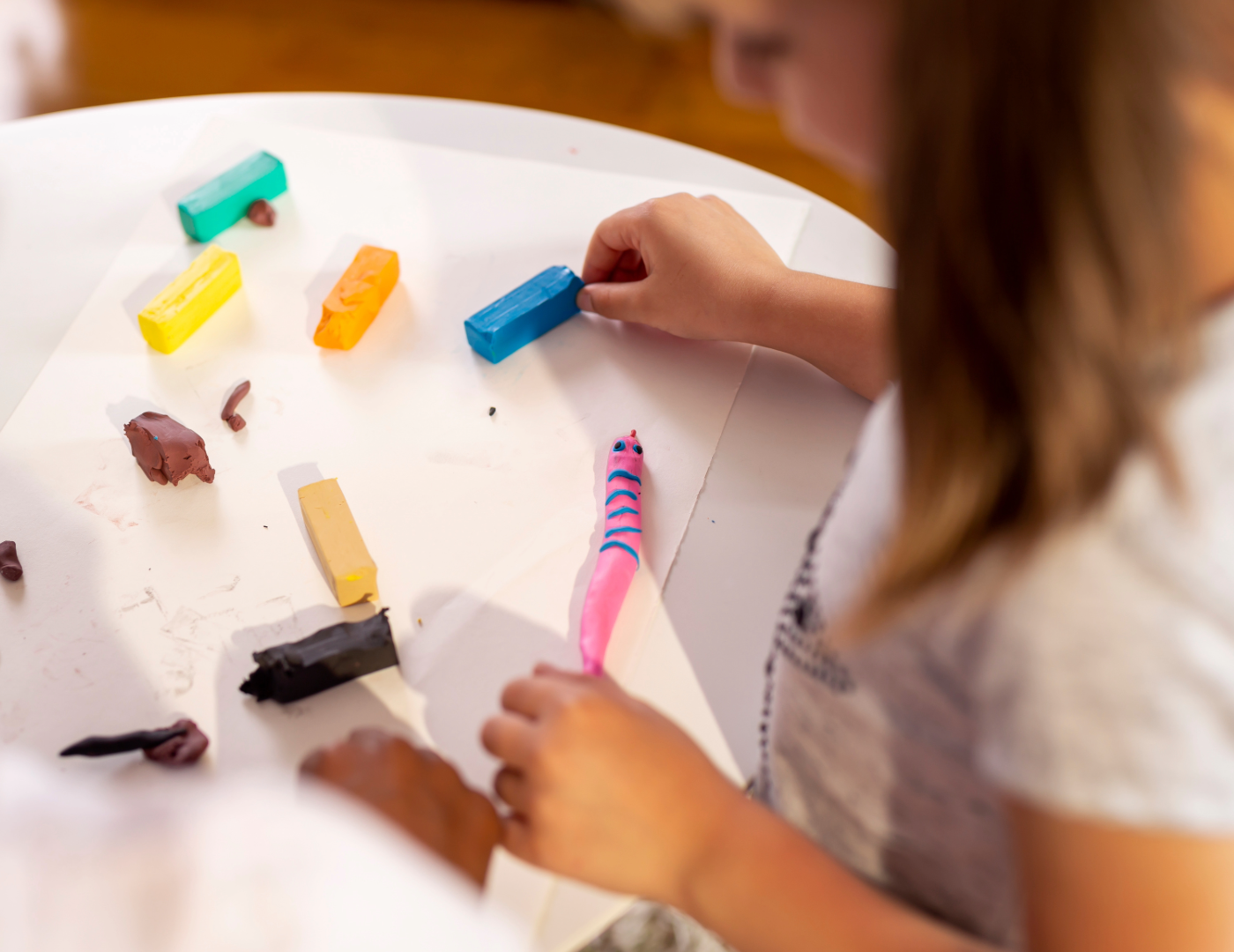 child crafting clay out of colorful clay