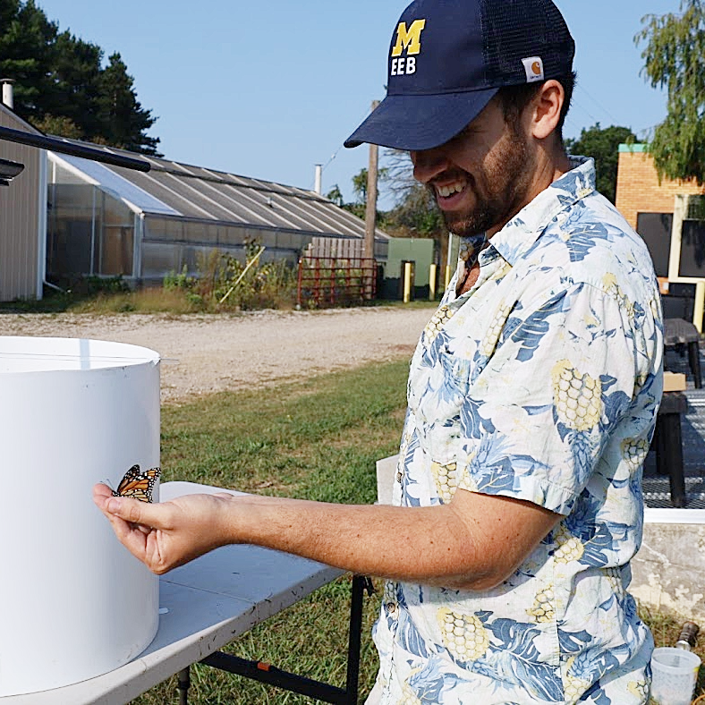 Sam Stratton gently holding a monarch butterfly