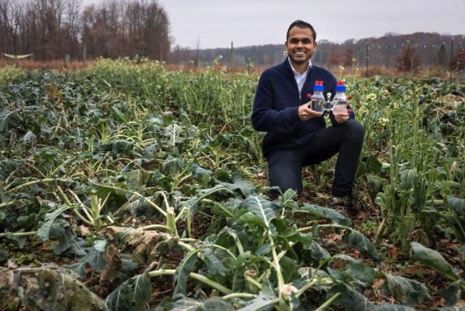 Photo caption: Dr. Joshua Jack, Assistant Professor in Civil and Environmental Engineering, holds the reactor at Campus Farm, 2025.