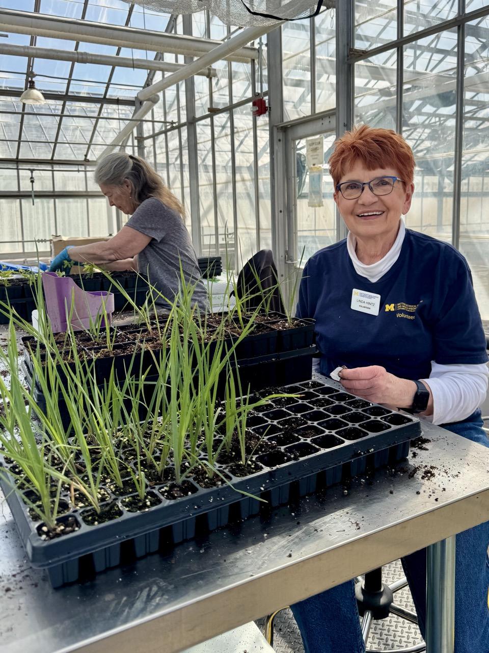 Volunteer Linda smiles while working with plants