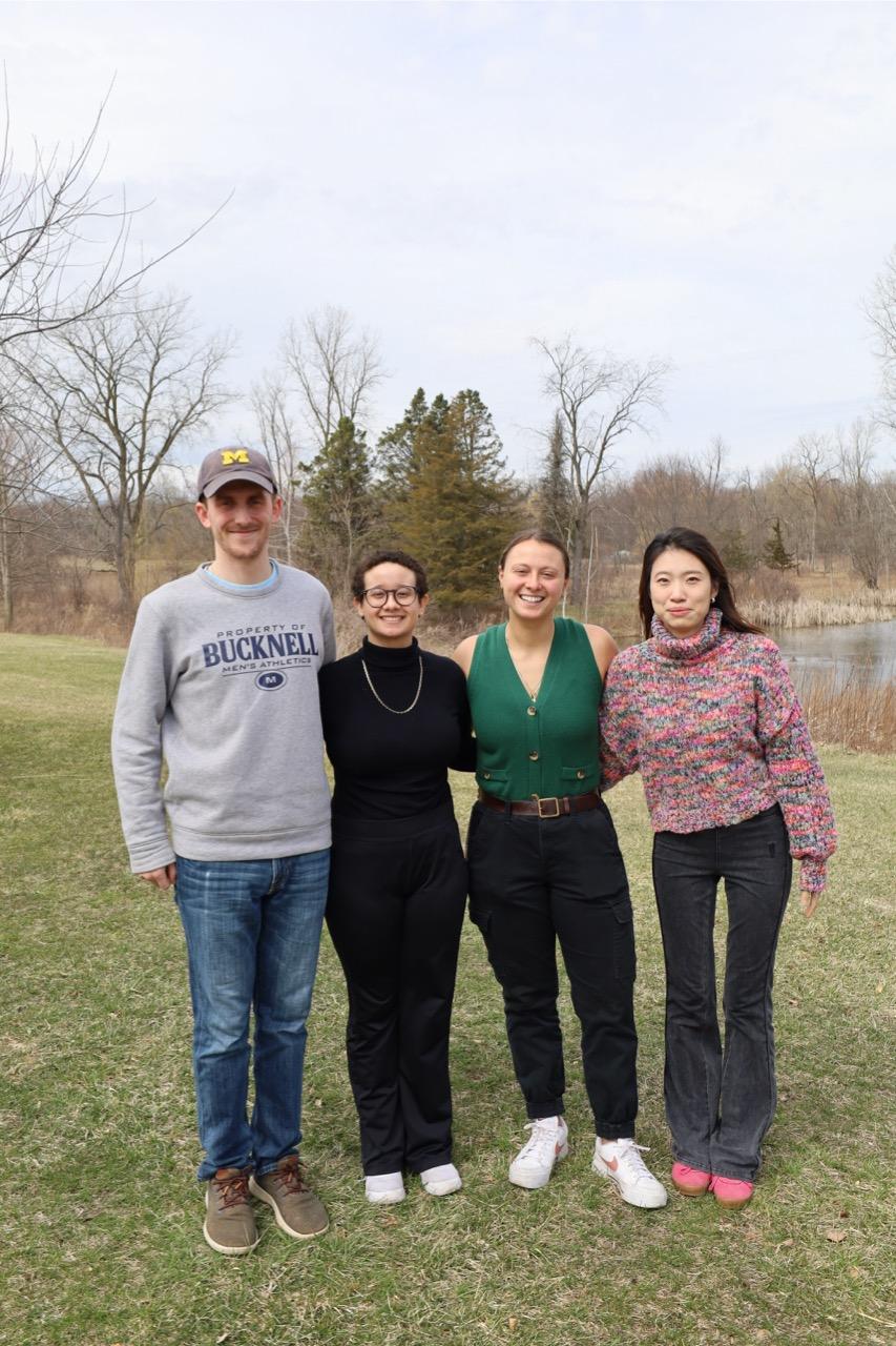 group of four students standing outside