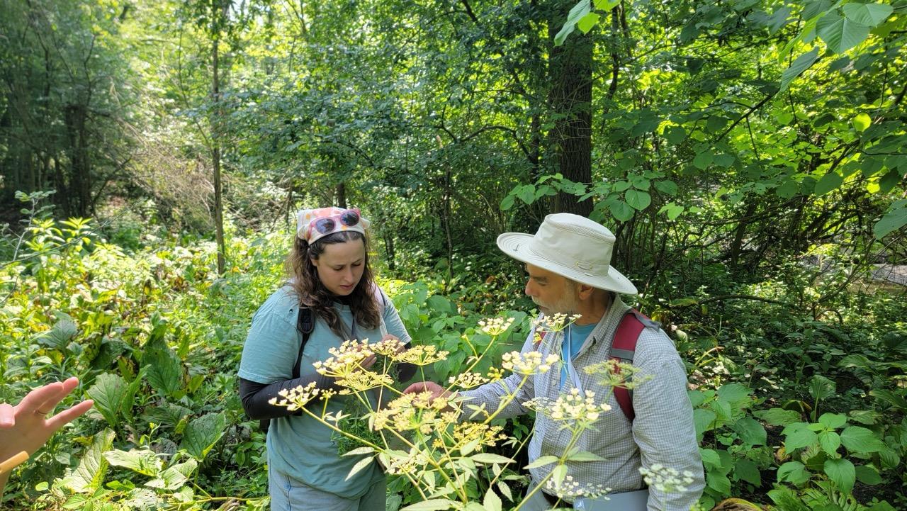Mike Kost and student look at plants outside