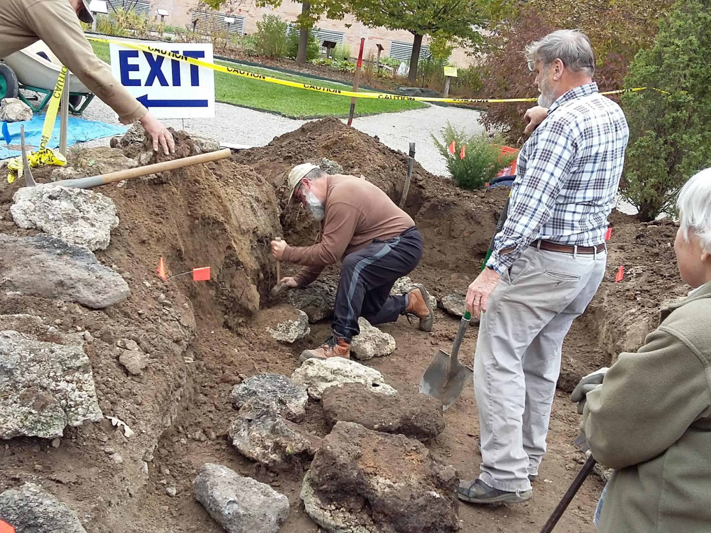 Two people work on rock garden whole two other look on