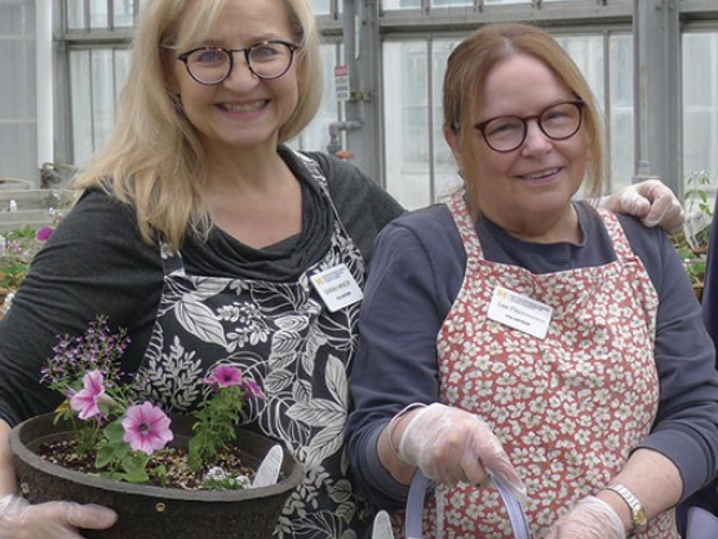 Two volunteers in aprons smiling at the camera