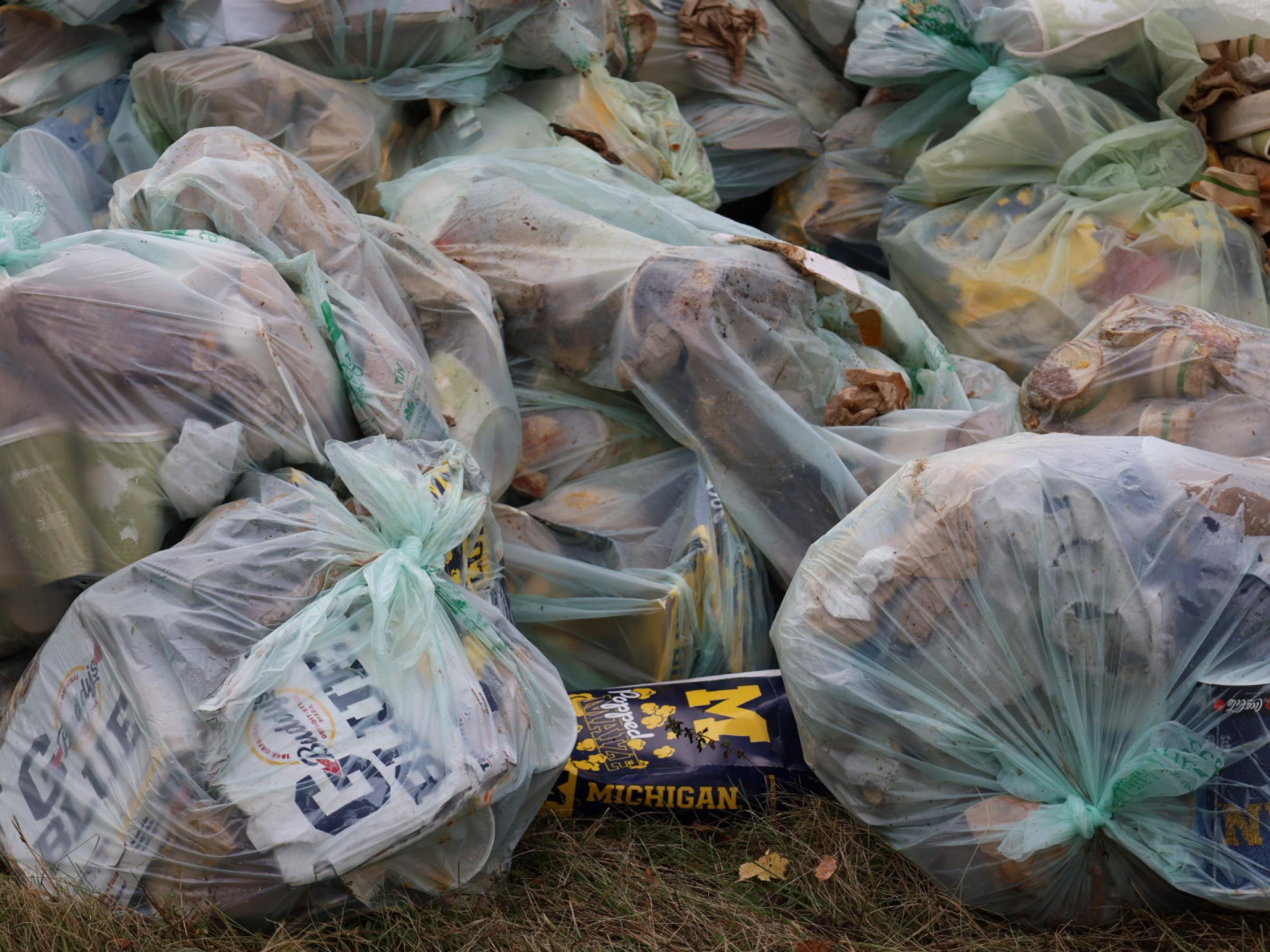 Clear garbage bags filled with waste from football game