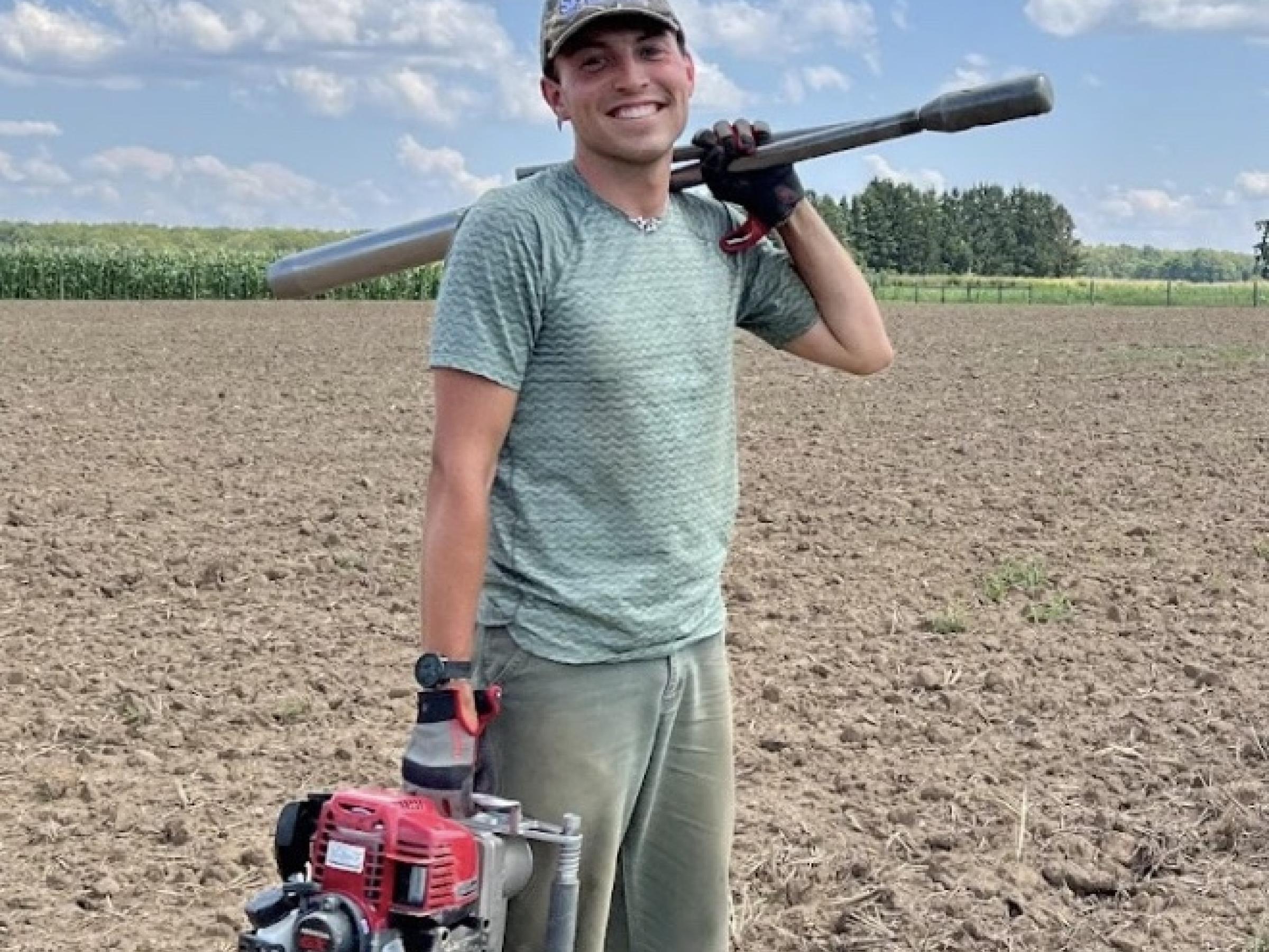 Will Brinkerhoff in field of dirt with tools