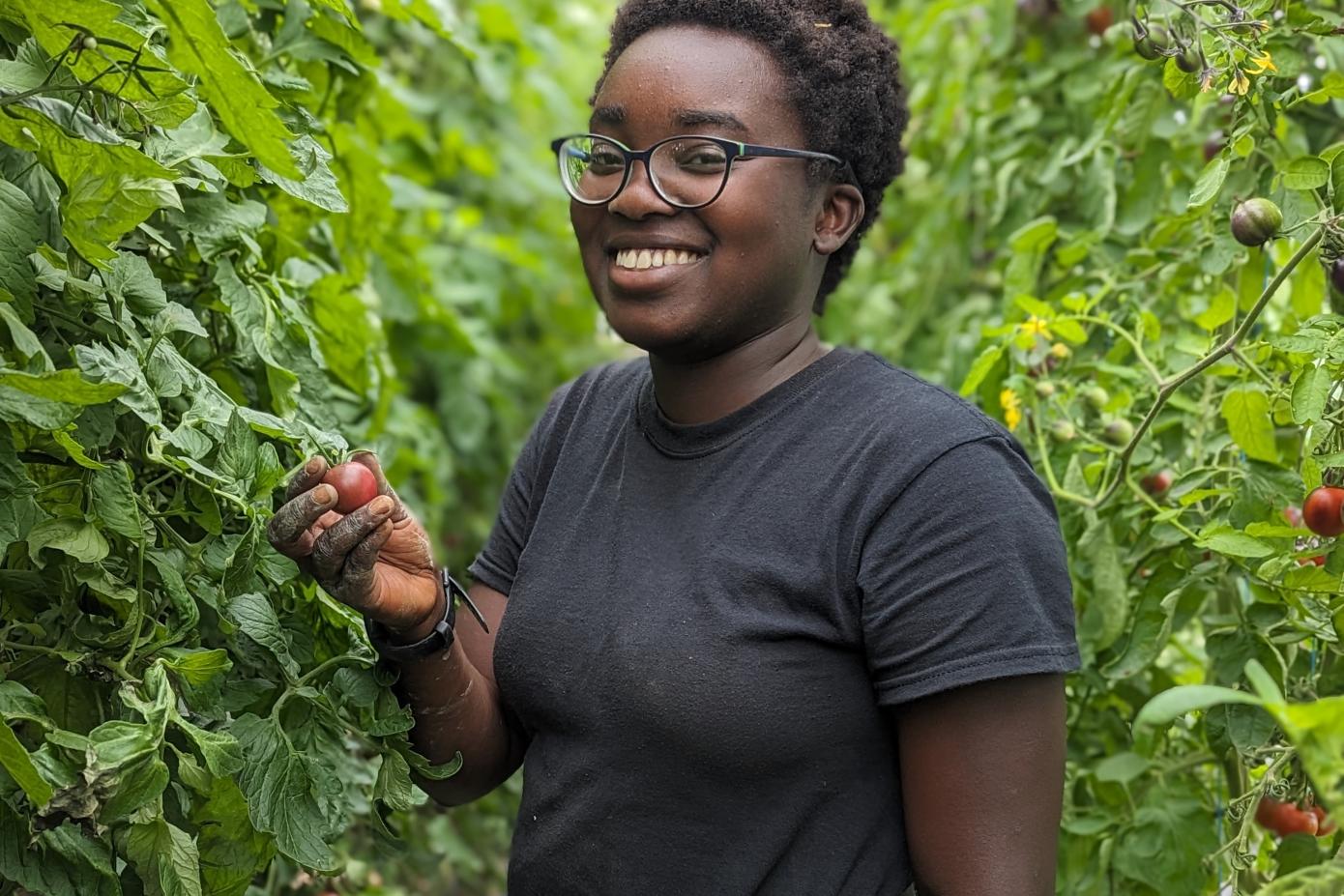A smiling student in the campus farm