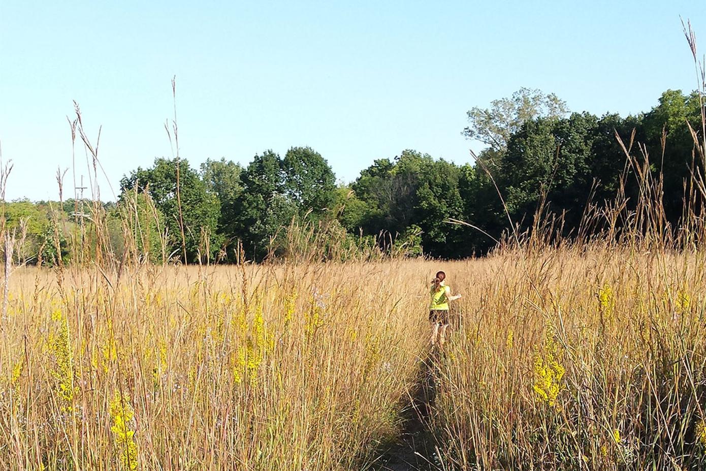 Person running along a trail through the field