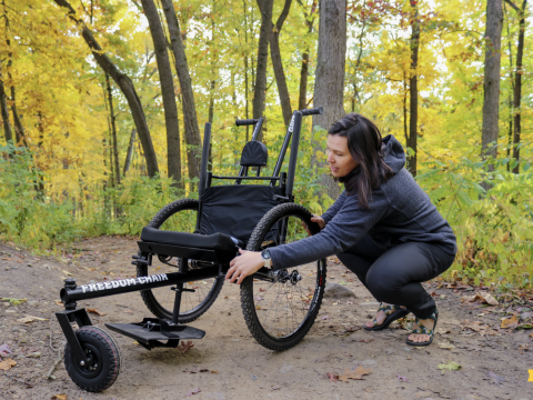 Kiley Adams adjusts the trailchair while on a trail at nichols arboretum