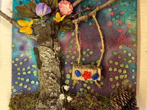 Natural materials art collage with a tree and swing shown