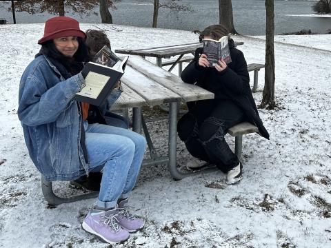 shazmin and 2 others at a table outside reading