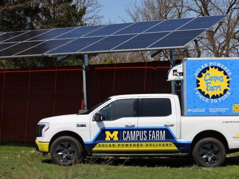 Campus Farm EV truck parked under solar array 