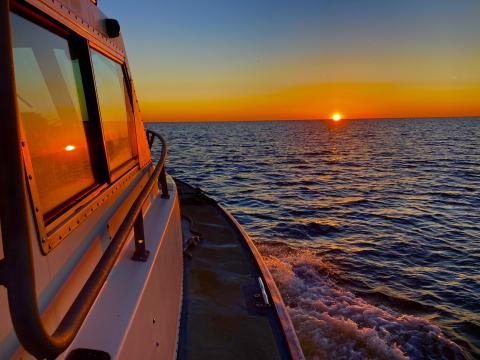 boat on lake with sunset