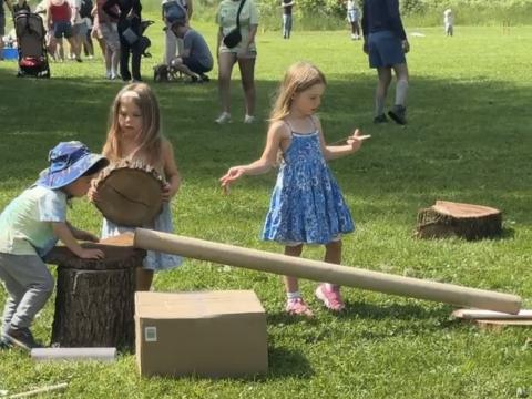 three children play with tubes and balls