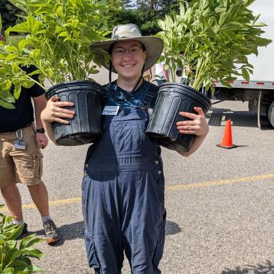 Intern holding two potted plants