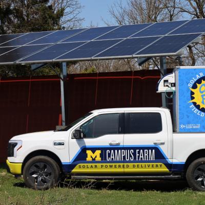 Campus Farm EV truck parked under solar array 
