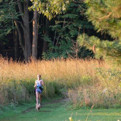 person walking dog in Nchols Arboretum