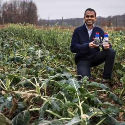 Photo caption: Dr. Joshua Jack, Assistant Professor in Civil and Environmental Engineering, holds the reactor at Campus Farm, 2025.