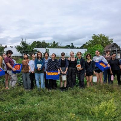 Group of students at the Campus Farm, some holding crates of tomatoes